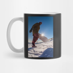 Snowboarder walking against blue sky Mug